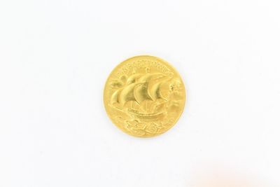 gros plan d'une pièce d'or sur une surface blanche