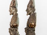 pair of bronze busts of a man and a woman wearing hats