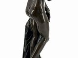 bronze statue of a woman kneeling on a pedestal with her hands on her knees