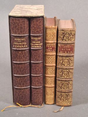 deux vieux livres posés l'un à côté de l'autre sur une surface grise