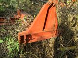 a rusted orange piece of machinery sitting in the grass