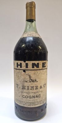une vieille bouteille de vin posée sur une table blanche