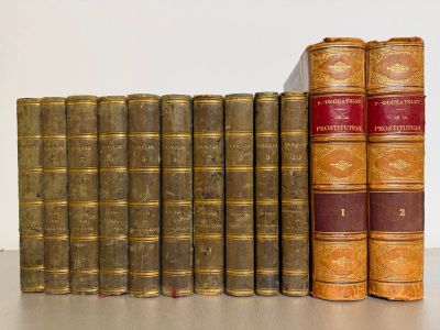 several old books are lined up in a row on a table