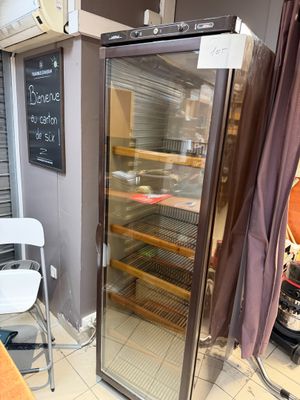 un réfrigérateur à porte vitrée dans un coin de la pièce