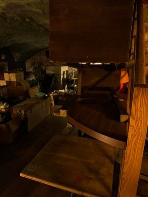 une échelle en bois au milieu d'une pièce remplie de cartons