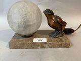 a statue of a bird and a ball on a marble base
