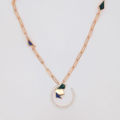 un collier à chaîne en or orné d'un pendentif géométrique vert et bleu