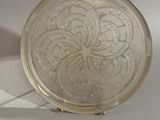une petite plaque en verre ornée d'un motif floral