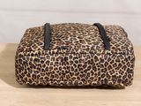 an animal print bag sitting on top of a wooden table
