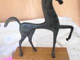 a statue of a horse that is on a wooden stand