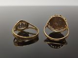 two gold rings with a stone in the middle and a diamond in the middle