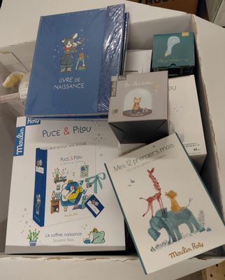 beaucoup de livres qui se trouvent dans une boîte posée sur la table