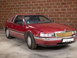 a red car that is parked in front of a brick wall