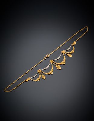 un collier en or et en argent orné de feuilles sur fond noir