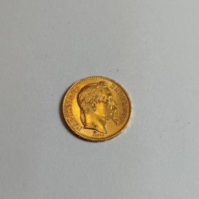 gros plan d'une pièce d'or sur une surface blanche