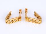 a pair of yellow gold cuff earrings with filigree design