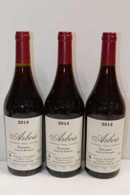 trois bouteilles de vin sont alignées sur une table