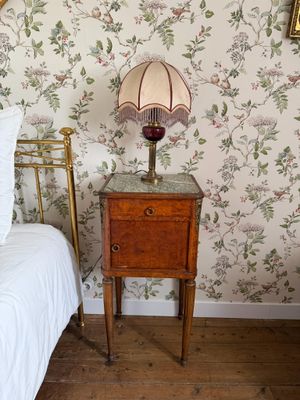 un lit sur lequel se trouvent une couette blanche et une lampe