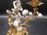 une statue représentant une femme tenant un vase posé sur une table