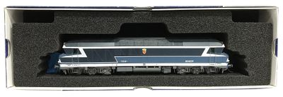 un train bleu et blanc dans une boîte posée sur une surface blanche