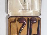 a small case with a pair of pipe holders inside of it