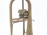 an old brass trumpet sitting on top of a white surface