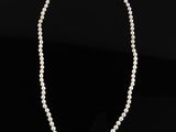a white pearl necklace on a black background