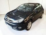 une voiture noire garée dans une pièce blanche