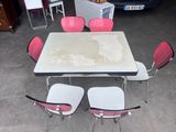 a table and four chairs in a room with a car in the background