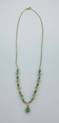 un collier vert et doré orné d'une croix