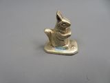 a gold figurine of a cat sitting on a plate
