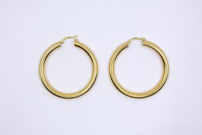 a pair of gold hoop earrings on a white background