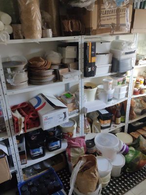 des étagères remplies de provisions et de produits d'épicerie dans une cuisine au sol en damier