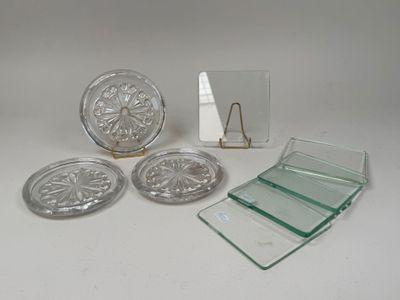 quatre dessous de verre en verre et un miroir posés sur une table