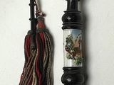 a picture of a stick with a handle and a tassel hanging on it