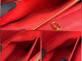 a close up of a red purse with a gold zipper