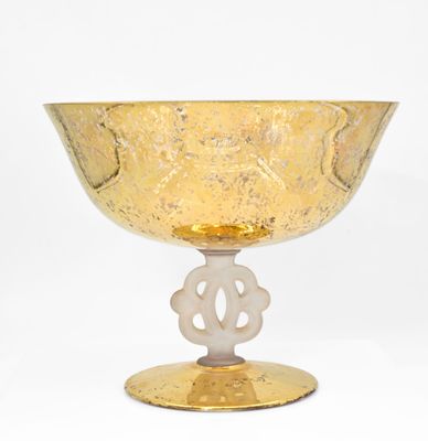 un bol en verre jaune avec un socle doré sur fond blanc