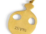 a close up of a gold plated pendant with a hole in the middle