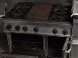 une cuisinière sur laquelle est posée une casserole, dans une cuisine