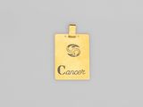 un pendentif plaqué or sur lequel est gravé le mot « cancer »