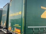 un semi-remorque vert avec un logo « Z » jaune sur le côté