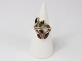 a close up of a ring with multi colored stones on a white cone