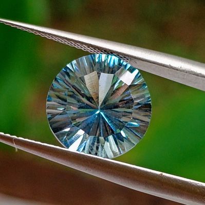 a blue diamond that is being held by a pair of pliers