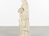 a white statue of a woman holding a bouquet of flowers