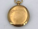 an old gold pocket watch with a chain hanging from it ' s side
