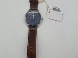 an image of a watch on a white surface with a tag on it