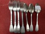 four silver spoons and two silver spoons on a red cloth