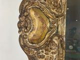 an ornately carved mirror with gold paint and gold leaf decoration