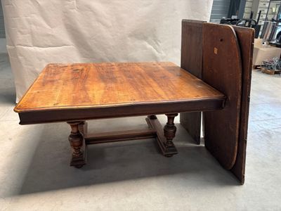 une table en bois avec un plateau rabattable au milieu d'une pièce