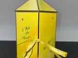 une boîte jaune à laquelle est noué un ruban jaune